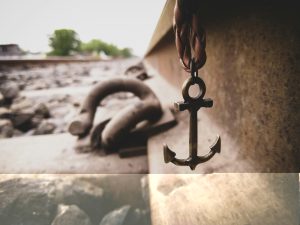 A small anchor with the sea behind, symbolising grounding and stability during constant life changes.