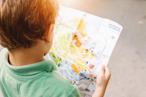 A boy studying a map, illustrating self-exploration, curiosity, and reflection in therapy. 